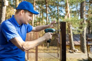 Beaverton Fence Installation by worker with a power tool